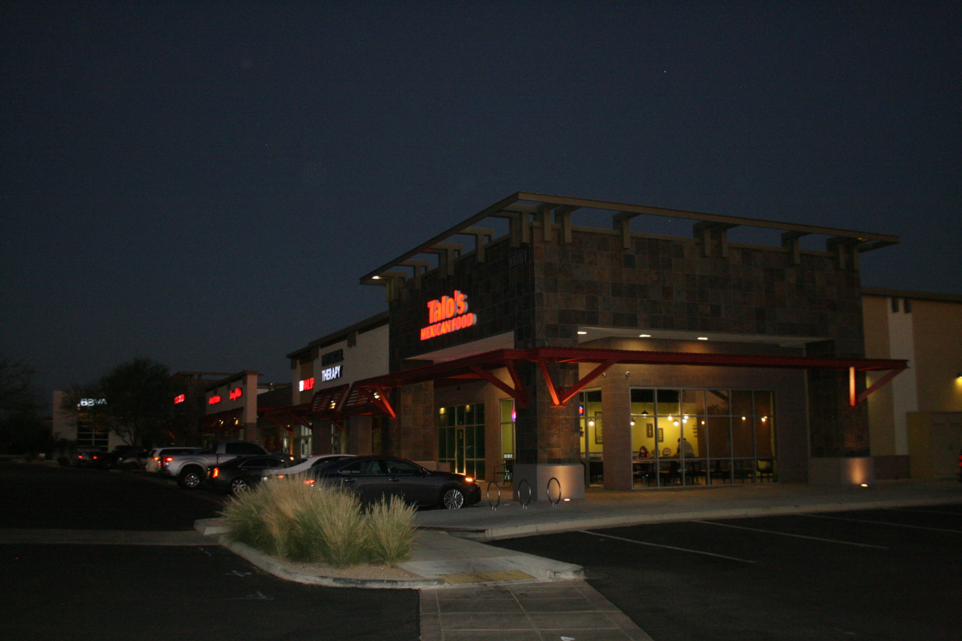 A night time picture of the outside of a restaurant.