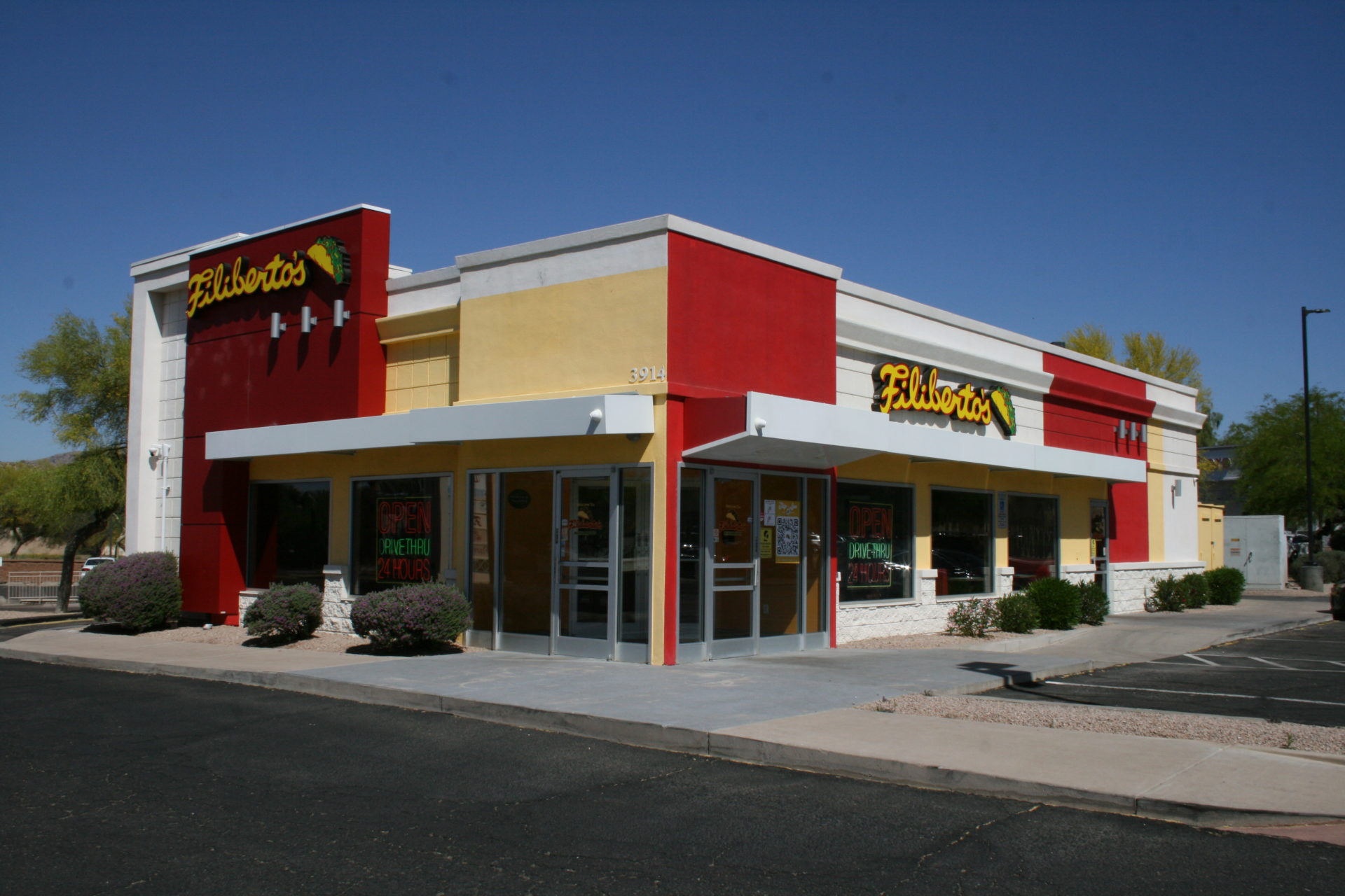 A restaurant with red and yellow walls on the side of the street.